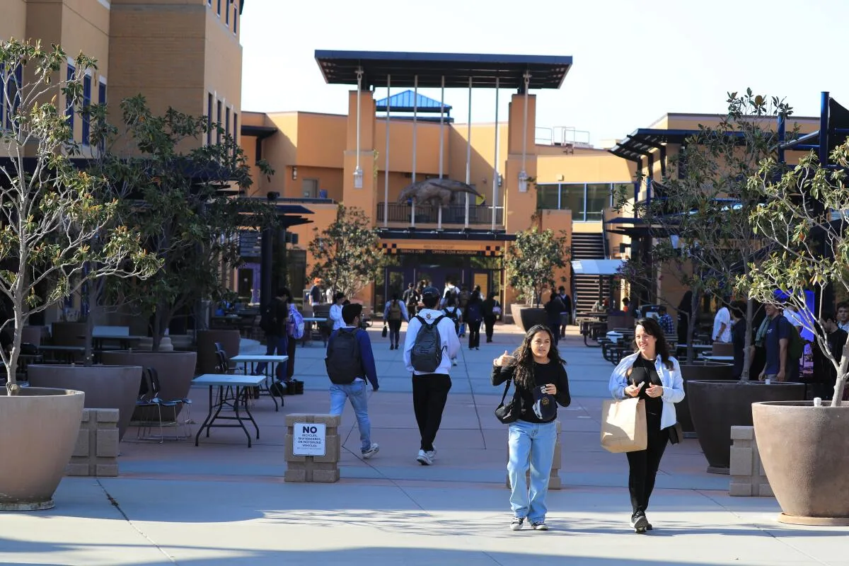 UC Math Crisis: 600+ Faculty Demand SAT Tests Back for STEM People walk in the UC Irvine courtyard.