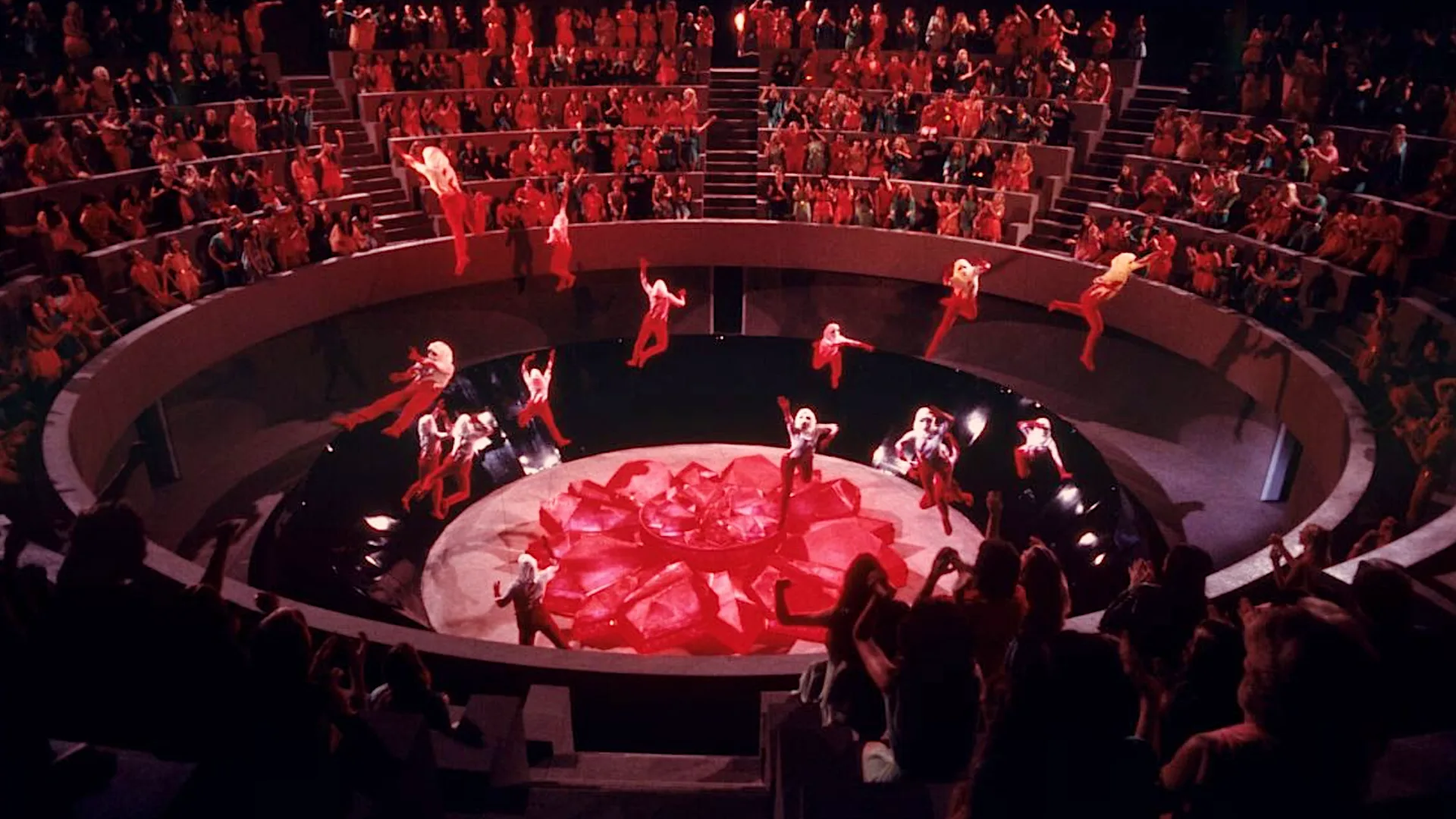 Logan's Run at 50: Why This Sci-Fi Classic Still Matters red-dressed figures rise into the air as spectators watch