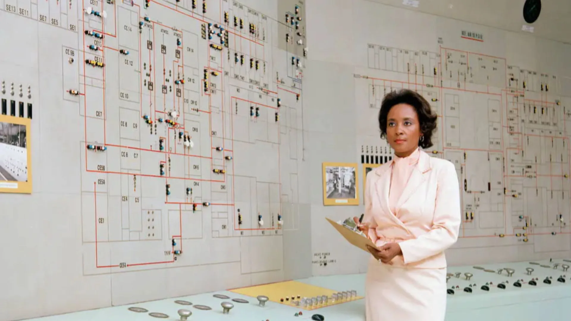 Annie Easley: The NASA Pioneer Who Helped Power the Space Age Annie Easley — A Black woman wearing a pale pink skirt suit set stands in front of a control board with diagrams.