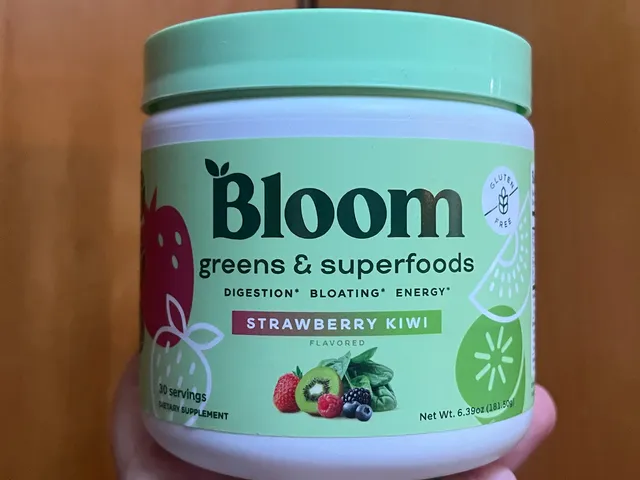Best Greens Powders 2026: Top 16 Picks, Expert-Tested A hand holding up a small teal container of Bloom Nutrition Superfood Greens Powder