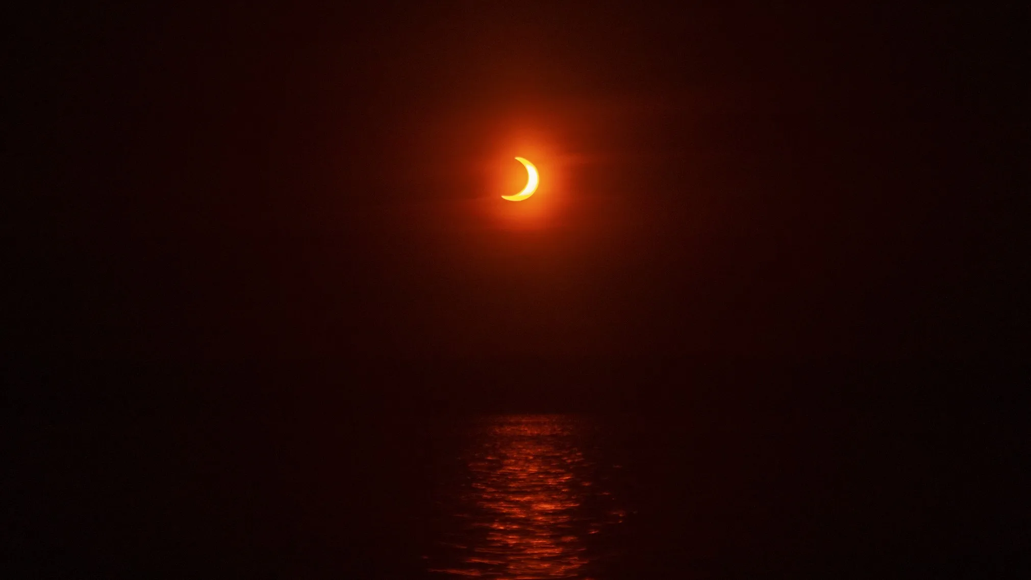 2026 Solar Eclipse: Best Places to See a Partial Eclipsed Sunset eclipse occurring near sunset the crescent sun glows with a vibrant orange hue