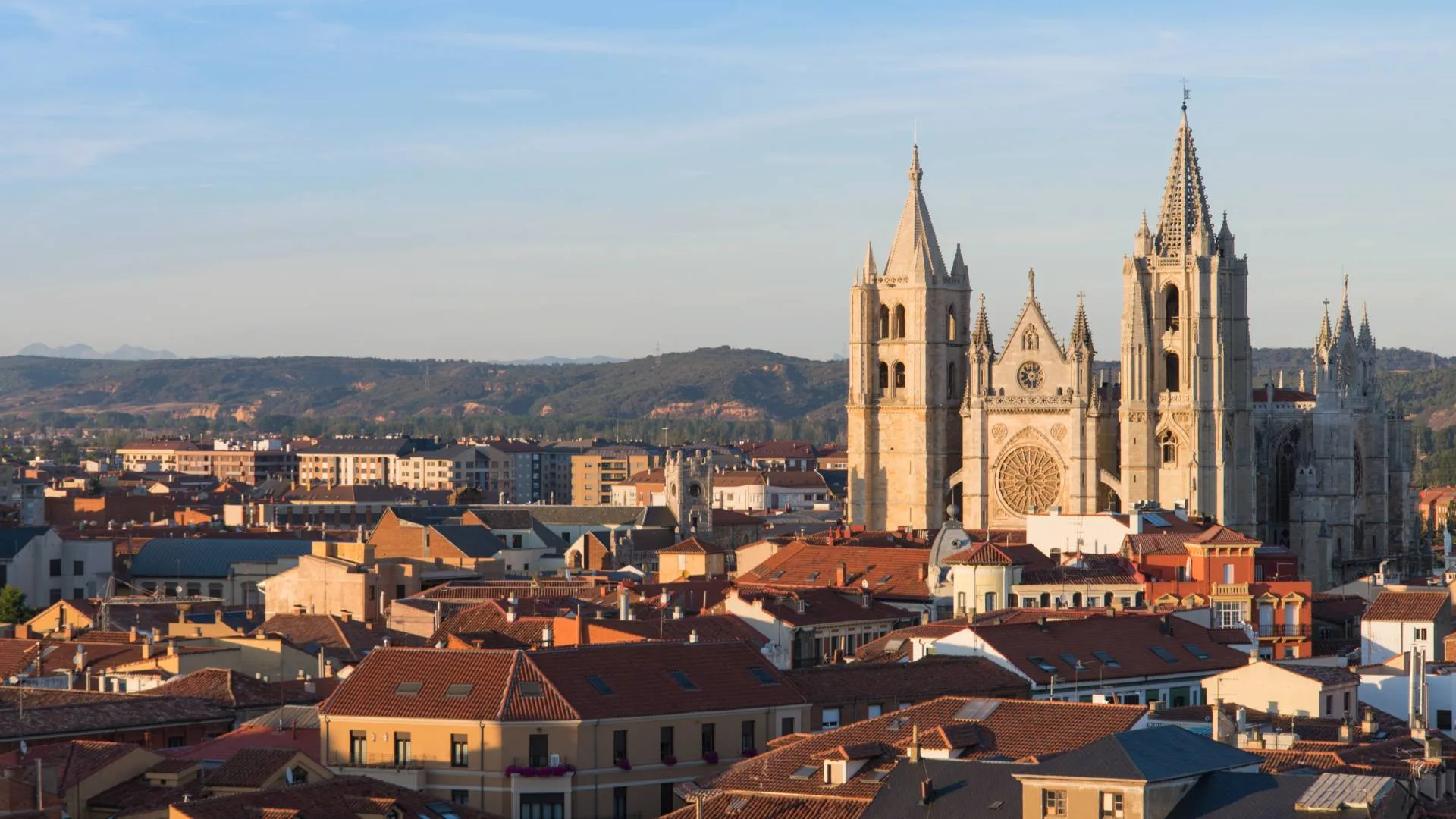 Spain Solar Eclipse 2026: Top 10 Cities for Best Views A panoramic view of a city with red-roofed buildings and the León Cathedral, a Gothic church with tall sp