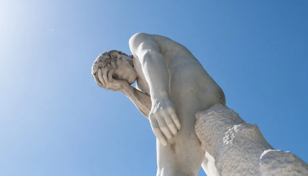 Claude Shared Chats Exposed a Critical Privacy Gap Man facepalming statue under the sun in the Tuileries garden.