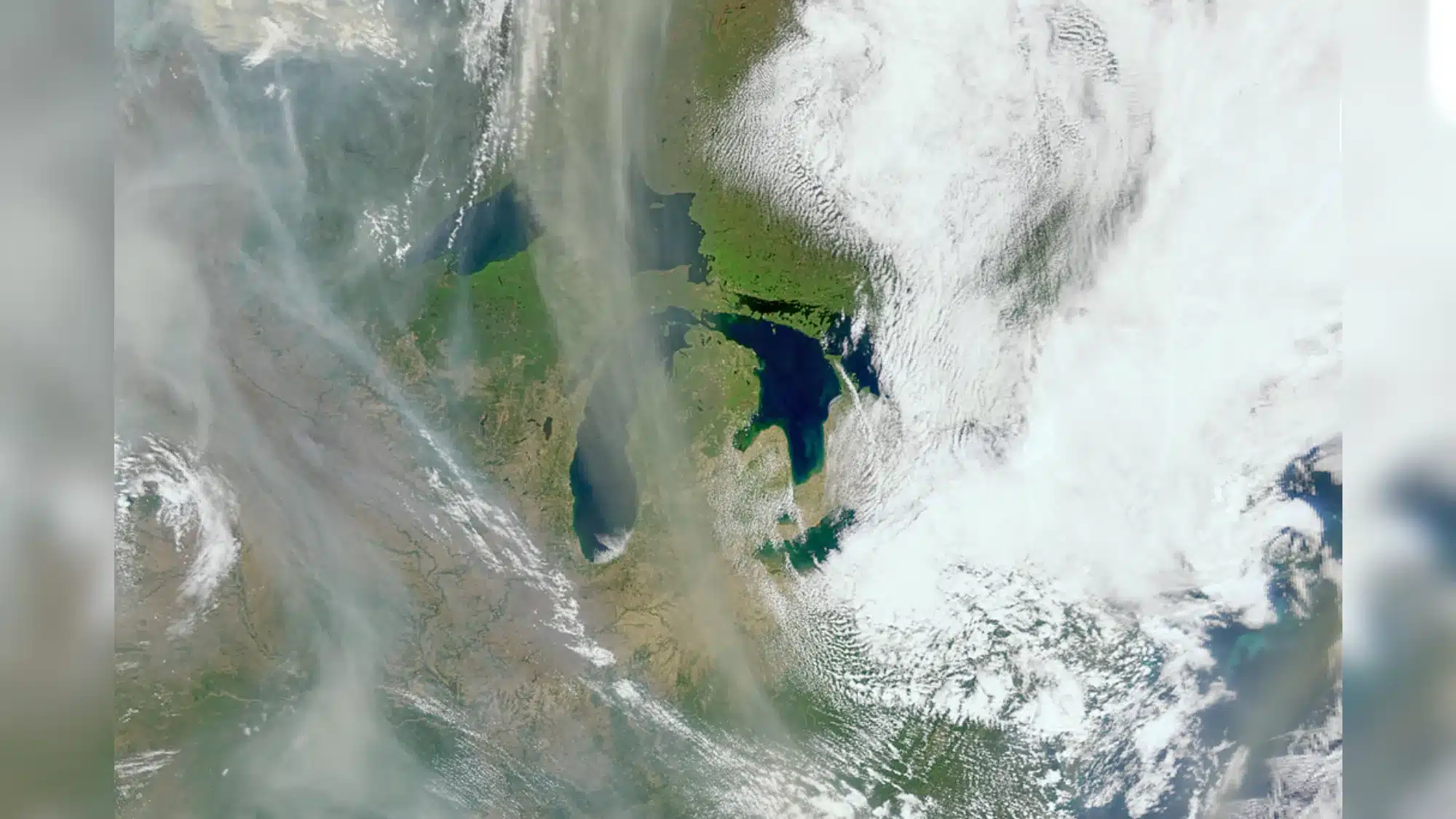 NASA's Ocean Satellite Reveals New Power as a Wildfire Tracker wildfire smoke from space — White and gray smoke hovers over an Earth landscape.