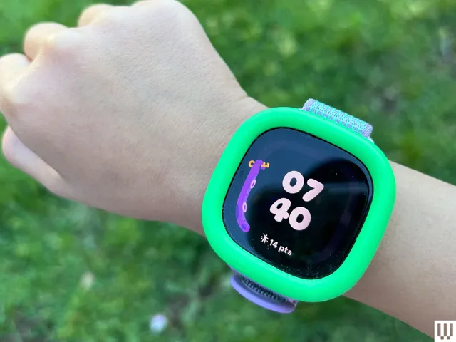 Best Fitbit Models in 2026: Expert Picks for Every Wrist Child's wrist with a digital wristwatch and the screen showing the time and game points earned