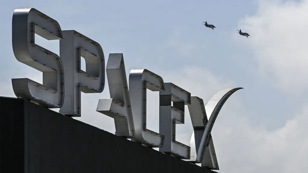 SpaceX AI Device: Latest on the New Phone-Like Prototype US billionaire businessman and pilot Jared Isaacman flies in formation aboard a fighter jet over the SpaceX sign, close