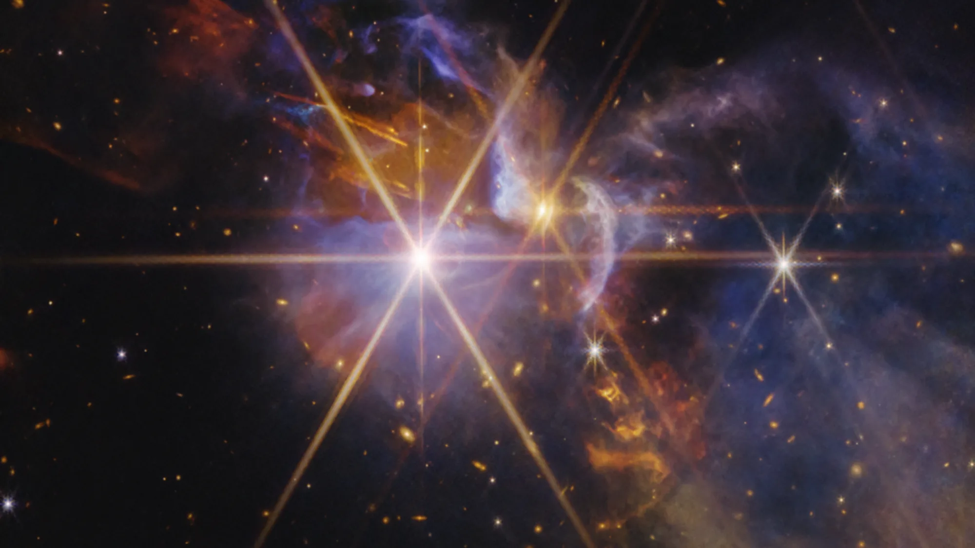 James Webb Telescope Captures New Images of Infant Stars in FS Tau infant stars — Blue and gold swirls between bright spiked stars against a black background