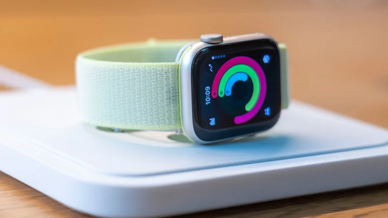 Apple Watch Battery Replacement: The $99 Decision Explained An Apple Watch Series 11 lying flat on a platform in a store showing rings.