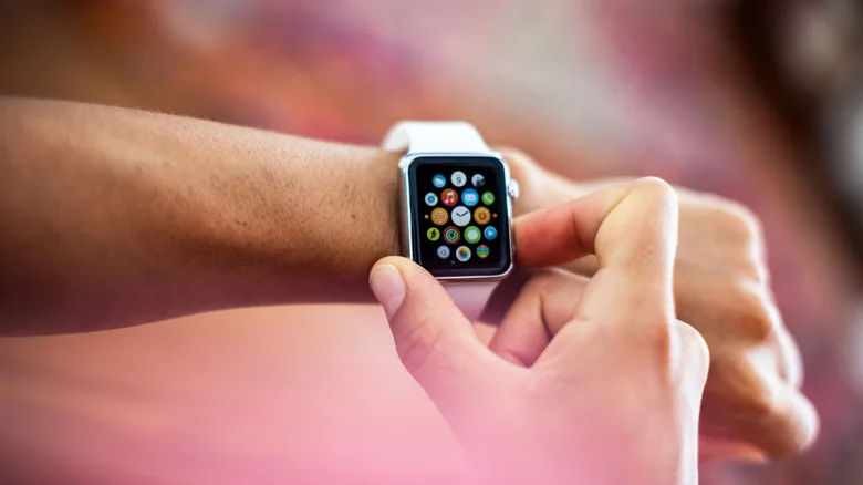 Apple Watch Battery Replacement: The $99 Decision Explained Apple Watch battery replacement — An arm held up with an Apple Watch on the wrist, as the other hand presses the side bu