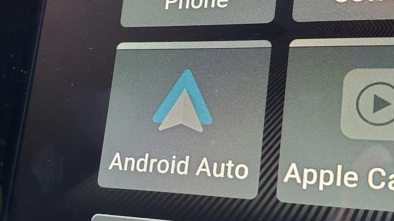 Android Auto vs CarPlay: The Key Differences for Drivers Android Auto vs CarPlay — An enlarged car screen with the Android Auto and Apple CarPlay app icons visible