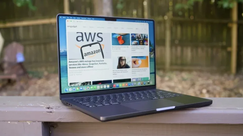 Touchscreen MacBook Could Mark Apple’s Biggest Laptop Bet touchscreen MacBook 2026 — Photo of a MacBook Pro displaying the Engadget website. The laptop is placed on top of a wood